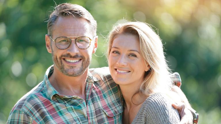 Smiling middle-aged couple outdoors, illustrating life insurance protection for couples